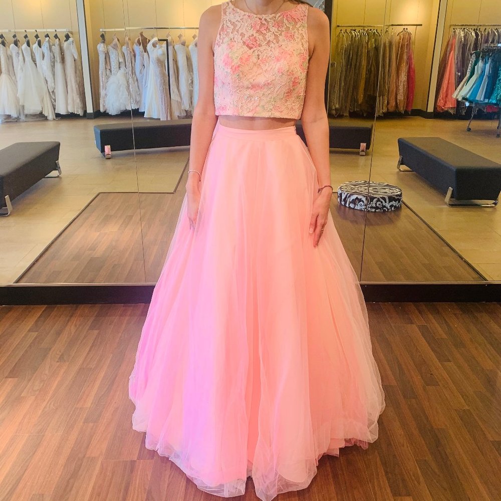 A high neckline is displayed with a floral lace